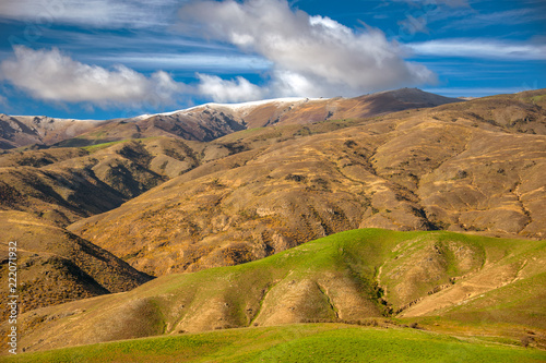 Beautiful color and texture of mountain and valleys in autumn, New Zealand. Some mountains start to be covered with snow, while other are green and turning golden brown. photo