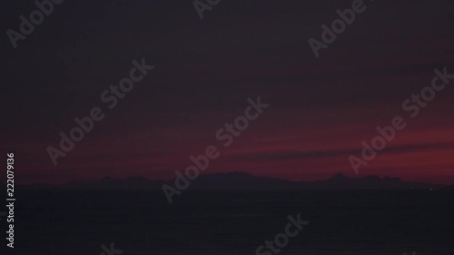 riceland, reykjavik harbour landscape / seascape during sunset and shortly after, dark moody atmosphere, camera movement, camera pan from left to right, medium shot on a long telephoto lens photo