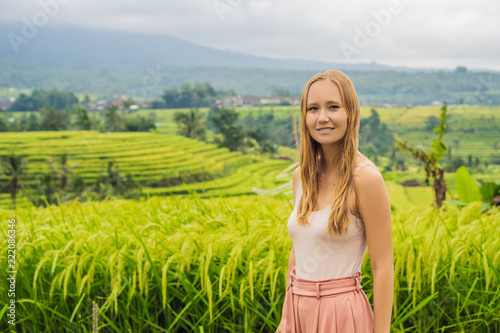 Young woman traveler on Beautiful Jatiluwih Rice Terraces against the background of famous volcanoes in Bali, Indonesia photo