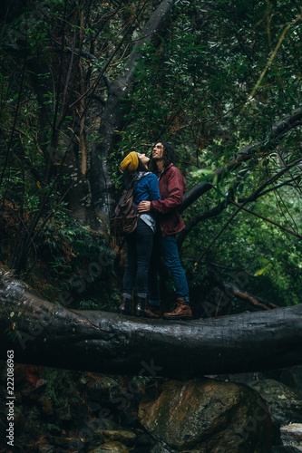 Couple in love getting wet in rain at forest