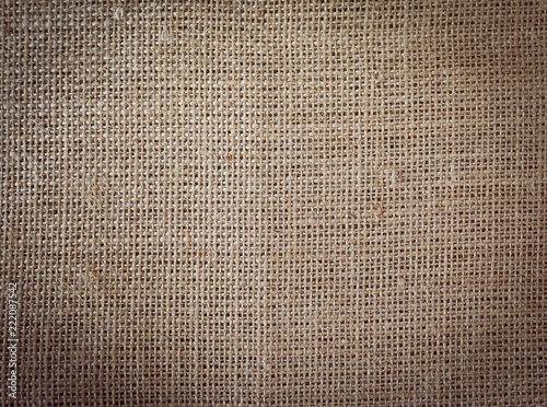 Texture of rough linen fabric. Toned. With a dark vignette.