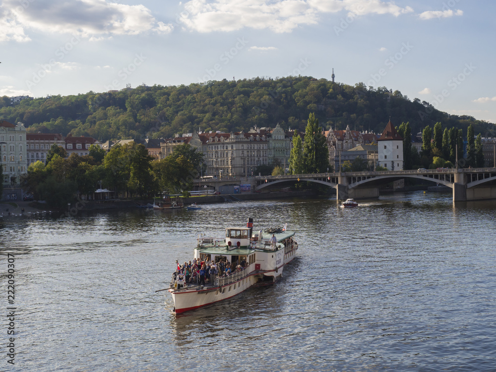 Czech Republic, Prague , September 8, 2018: View on Legion Bridge, Most legii and Vltava river, Moldau and houses on Mala Strana with tourist people relaxing on steamer boat Czech Republic, Prague , September 8, 2018: View on Legion Bridge, Most legii and Vltava river, Moldau and houses on Mala Strana with tourist people relaxing on steamer boat