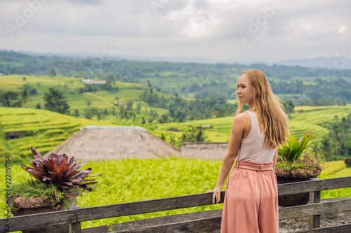 Young woman traveler on Beautiful Jatiluwih Rice Terraces against the background of famous volcanoes in Bali, Indonesia photo