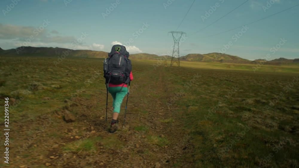 dramatic iceland landscape, person hiking on trail, camera following movmement, camera tracking / dolly in on a steadicam gimbal stabiliser