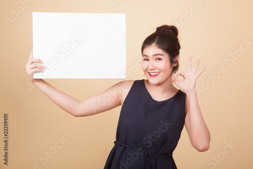 Young Asian woman show OK with white blank sign.