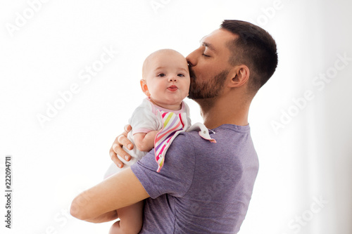 family, parenthood and people concept - happy father kissing little baby daughter photo