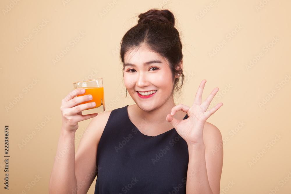 Young Asian woman thumbs up drink orange juice.