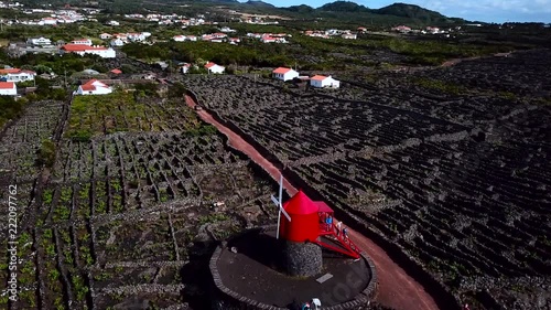 Aerial Shot of Red Windmill and UNESCO World Heritage vineyards in Sao Jorge island, Azores. Portugal photo