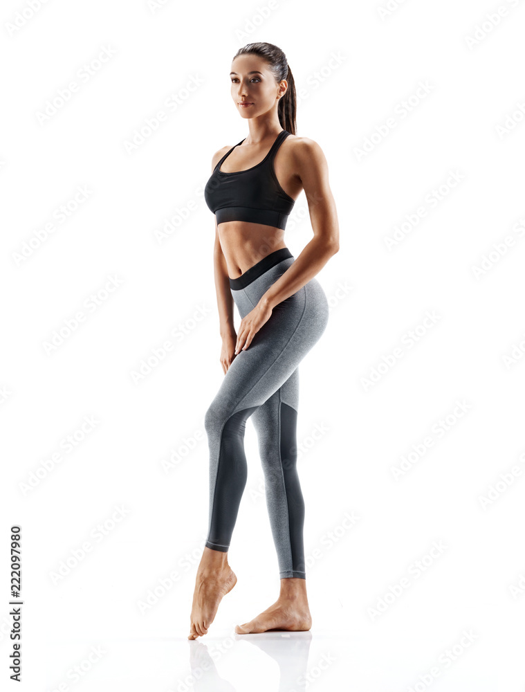 Young slim girl in sportswear isolated on white background. Concept of  healthy life and natural balance between body and mental development. Full  length Stock Photo