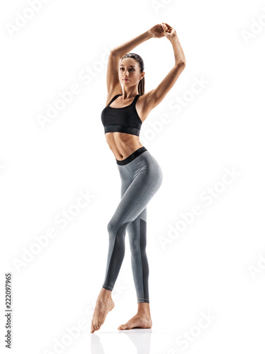 Young slim girl in sportswear isolated on white background. Concept of healthy life and natural balance between body and mental development. Full length