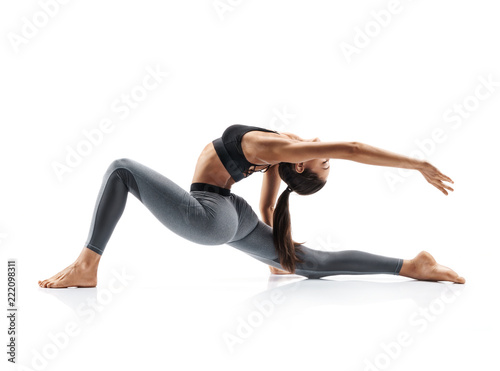 Young attractive girl practicing yoga isolated on white background. Concept of healthy life and natural balance between body and mental development. Full length