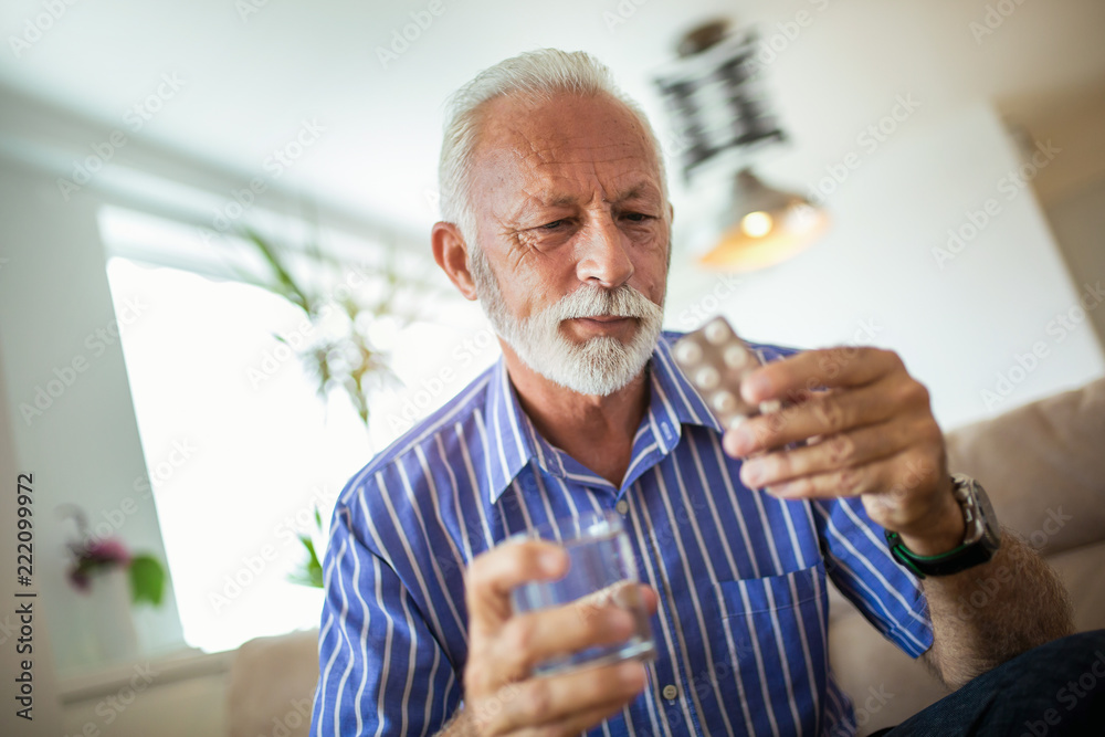 Senior man taking pills at home - obrazy, fototapety, plakaty 