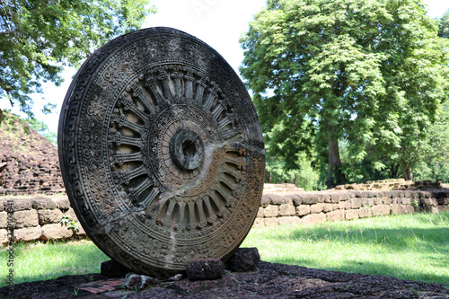 Stone carving of the wheel of the dharma. in archaeological site of Srithep ancient town in Petchaboon, Thailand. The influence of ancient Draravati culture, 8th-9th century A.D. photo