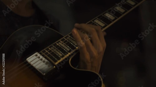 Guitar player playing rock music on concert stage. Close up hands of musician playing music at acoustic guitar. Guitarist plays melody on strings.