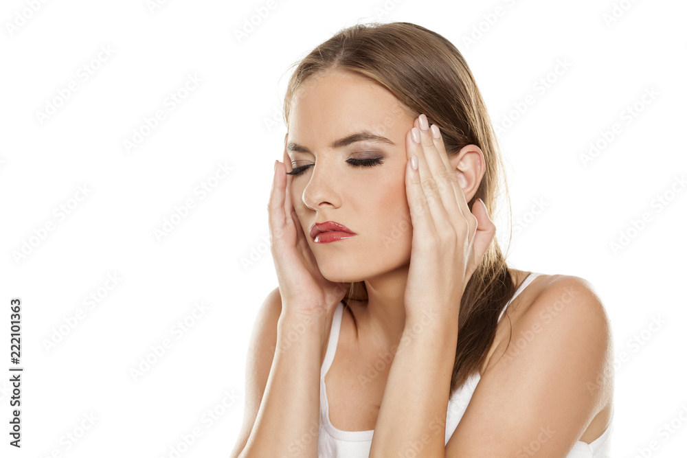 Beautiful girl with headache on white background