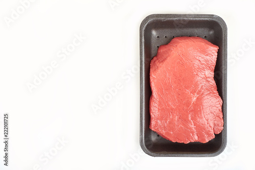 Big red meat chunk in package, on white background