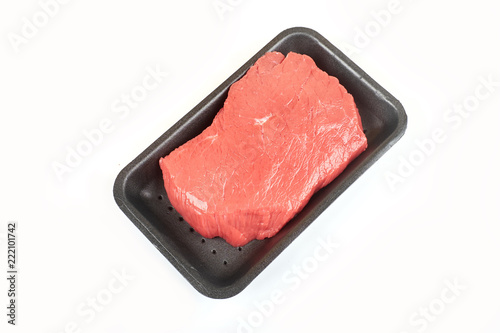 Big red meat chunk in package, on white background