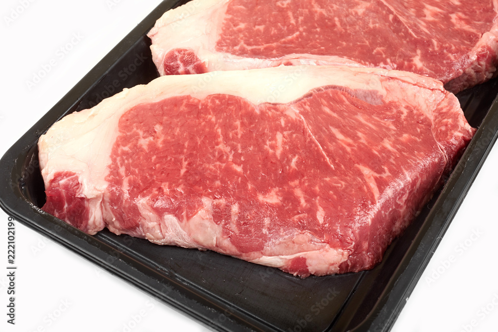 Raw steak in package. Isolated on white background. Raw steak in package. Isolated on white background.