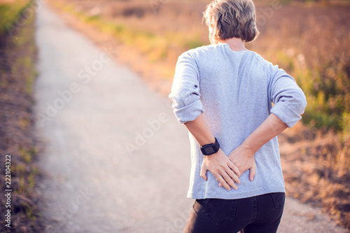 People, healthcare and problem concept - unhappy woman suffering from pain in back or reins outdoor photo
