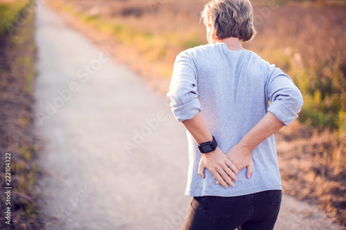 People, healthcare and problem concept - unhappy woman suffering from pain in back or reins outdoor