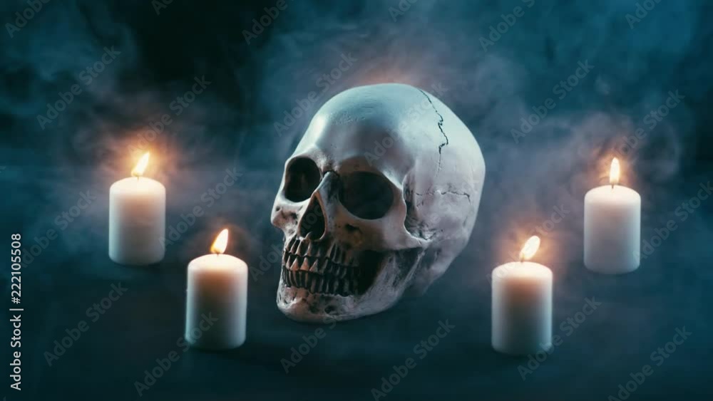 Skull between candles, halloween theme, lot of smoke, seamless loop Skull between candles, halloween theme, lot of smoke, seamless loop