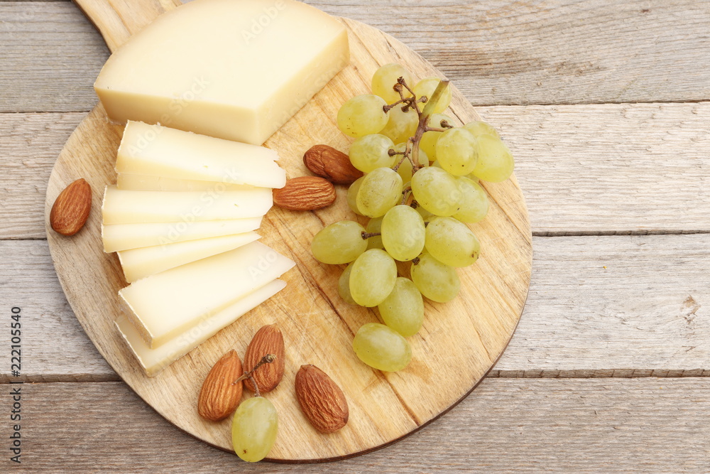 Cheese, grapes and almonds on a board Cheese, grapes and almonds on a board