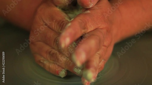 ceramic for  beginners- hands throwing a clay vessal on a pottery wheel photo