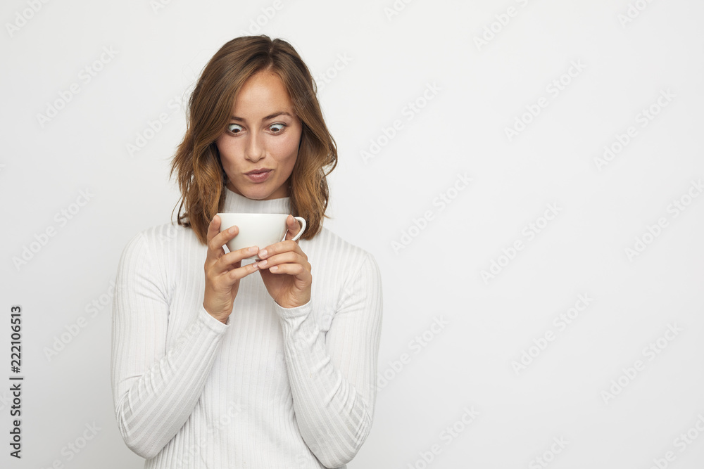 young woman with cup of coffee looks down funny young woman with cup of coffee looks down funny