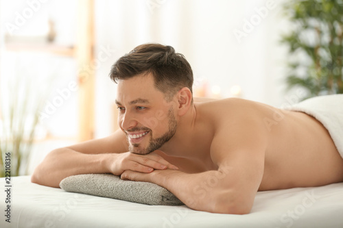 Man lying on massage table in spa salon