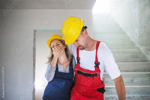 Принти на полотні Woman and man workers suffocating at the construction site.