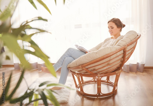Young woman reading book on...