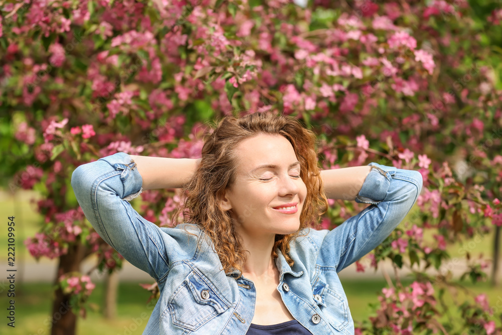 Portrait of beautiful woman near blooming tree in park Portrait of beautiful woman near blooming tree in park