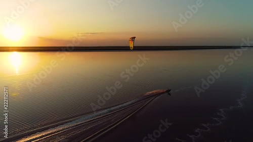 The setting sun above the lake, the wakeboard splashing on the water photo