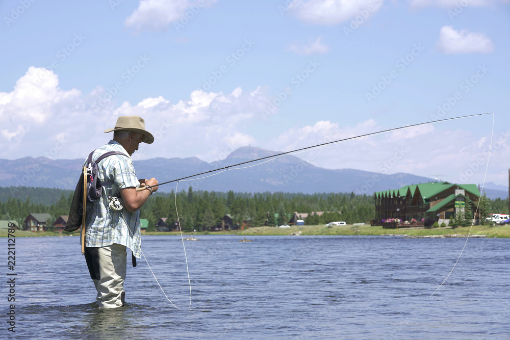 Fisherman putting fly on fishing line hook