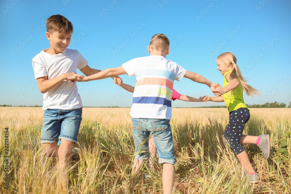 Cute little children playing in wheat field on sunny day Cute little children playing in wheat field on sunny day