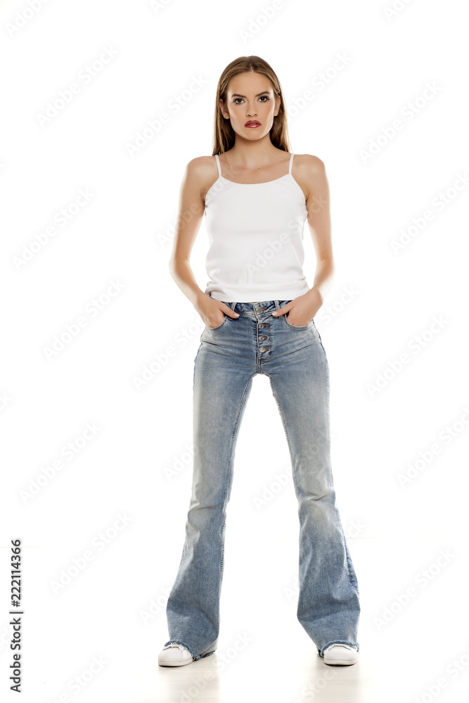 young pretty woman posing in bell bottom jeans on white background young pretty woman posing in bell bottom jeans on white background