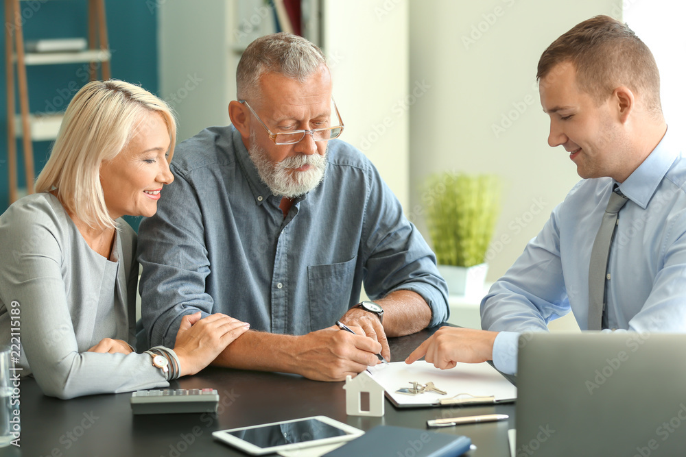 Mature couple with estate agent in office Mature couple with estate agent in office