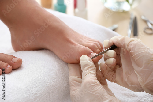 Young woman getting professional pedicure in beauty salon, closeup