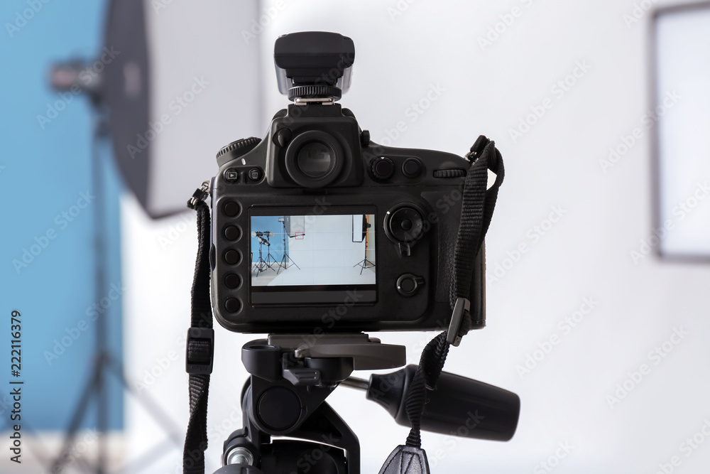 Professional camera on tripod in photo studio
