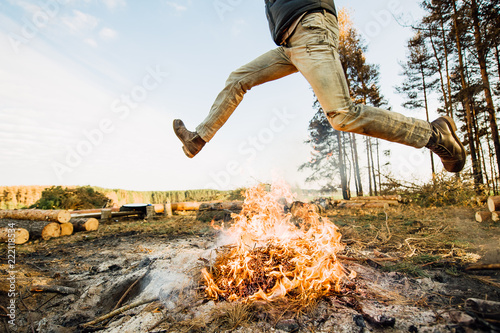 man is jumping over a fire