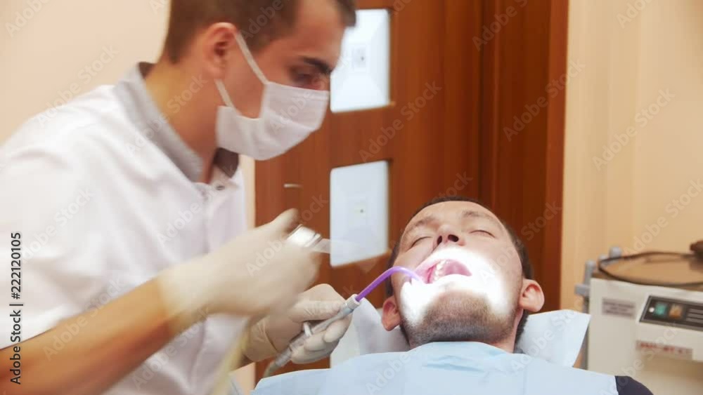 Male dentist in the process of treating a male patient's teeth. At the reception at the dentist in the clinic. Male dentist in the process of treating a male patient's teeth. At the reception at the dentist in the clinic.