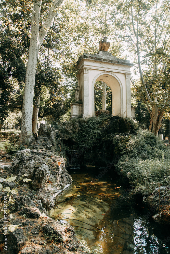 Sculptures in the parks of Rome, nature and architecture. Ancient monuments of culture. Arches and columns, fountain and lake. Flowering plant