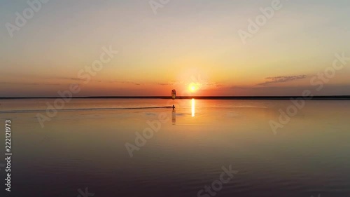 Bright sunset among the clouds, a kite rides on lake photo