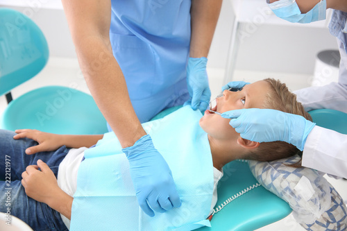Dentist examining little bo...