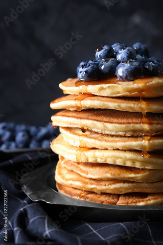 Plate with tasty pancakes and blueberries on table, closeup