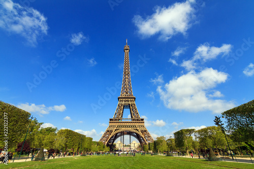 Beautiful vibrant spring view of the Eiffel tower in Paris, France, with a blue sky and some clouds © dennisvdwater