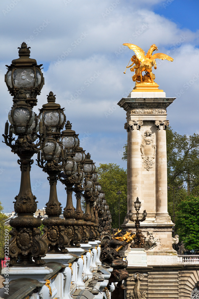 Fototapeta premium Ornate lanterns and statue at the Pont Alexandre III in Paris, France