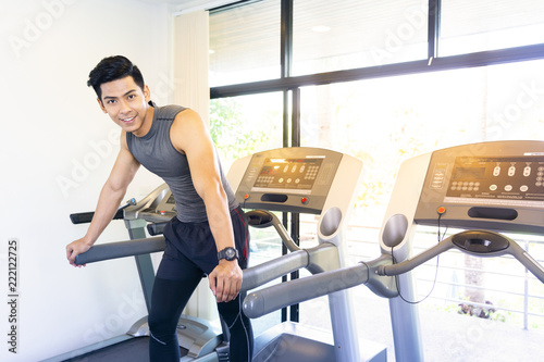 Portrait of happy mature men on treadmill in fitness center