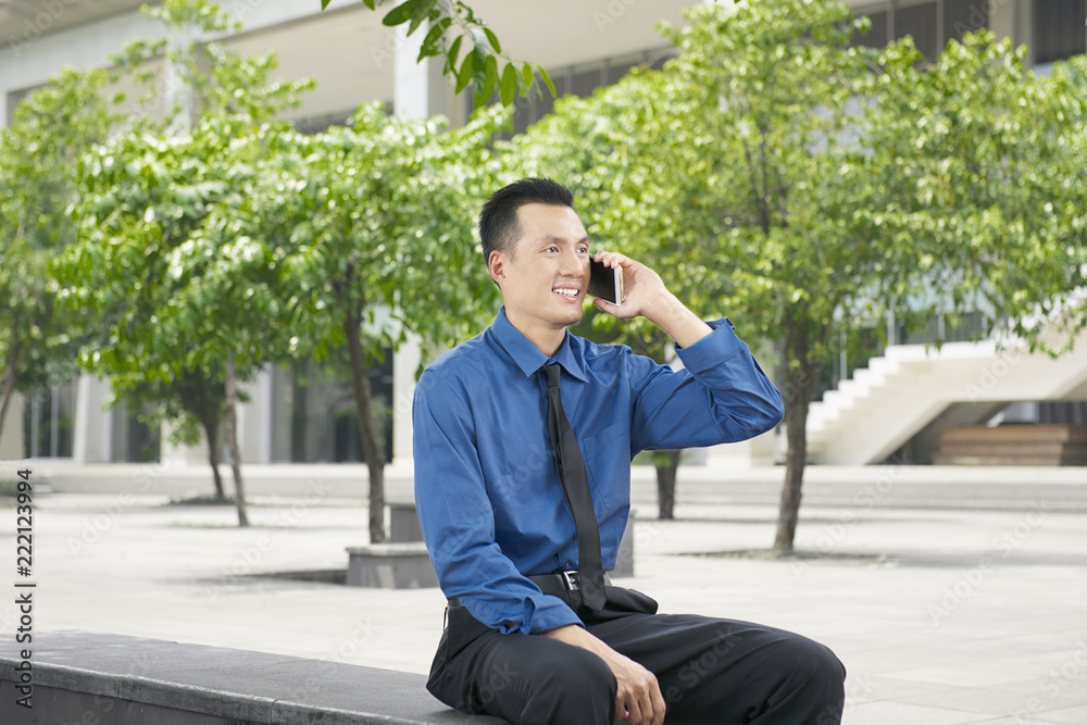 Young asian businessman talking on the phone Young asian businessman talking on the phone