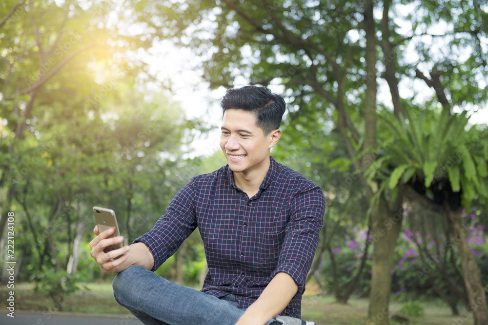 Handsome asian man using mobile phone and sit Handsome asian man using mobile phone and sit
